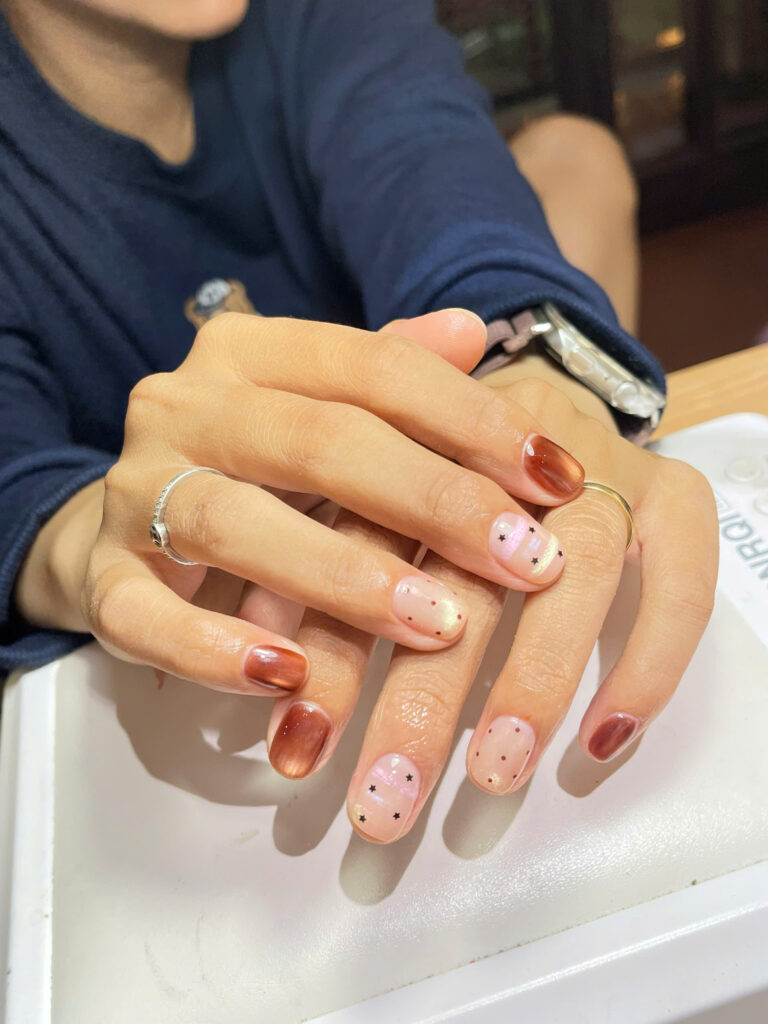 Brown cat-eye gel nails with tiny star and dot nail art at Art Spa 2, Hoi An