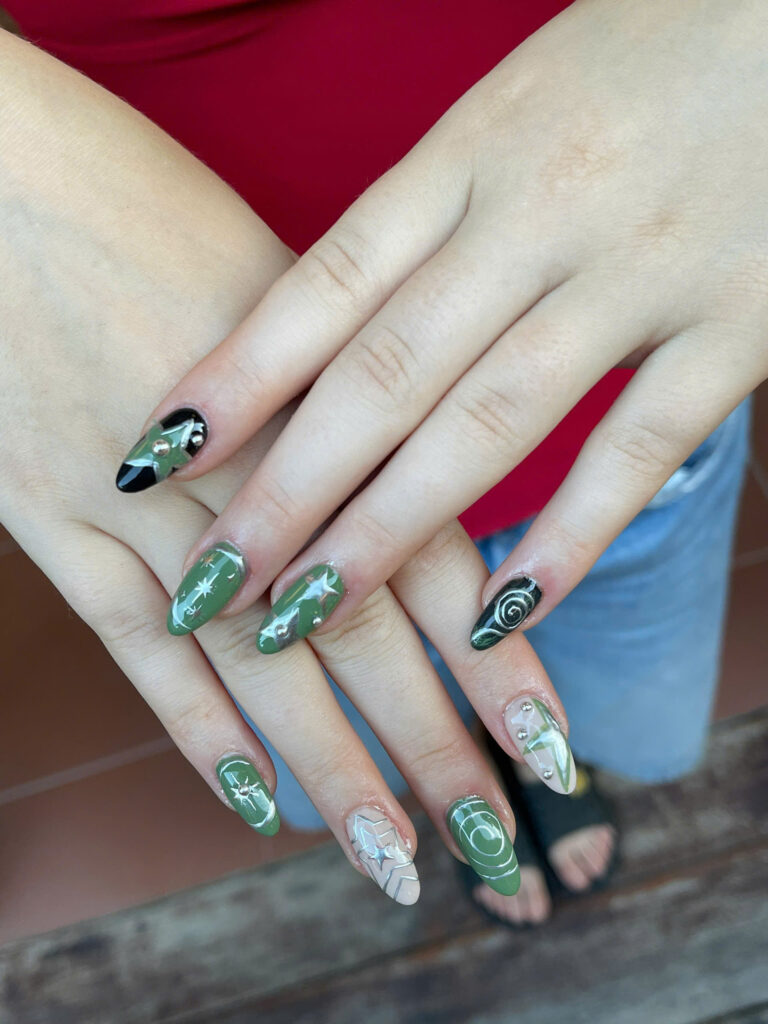 Green and black almond nails with silver chrome stars and swirls at Art Spa 2, Hoi An