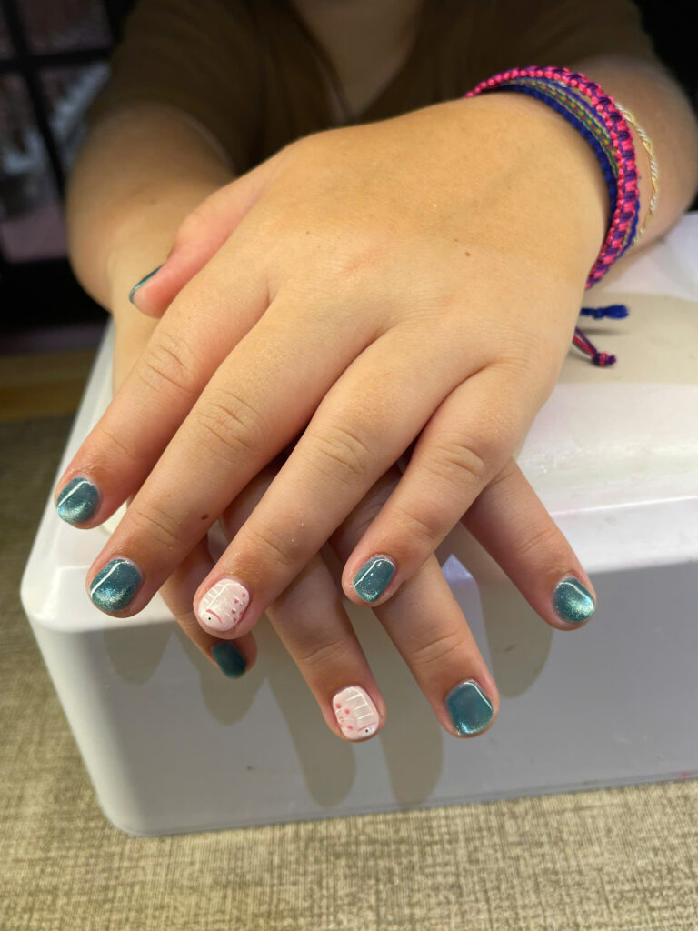Teal cat-eye gel nails with hand-painted white accent nails at Art Spa 2, Hoi An