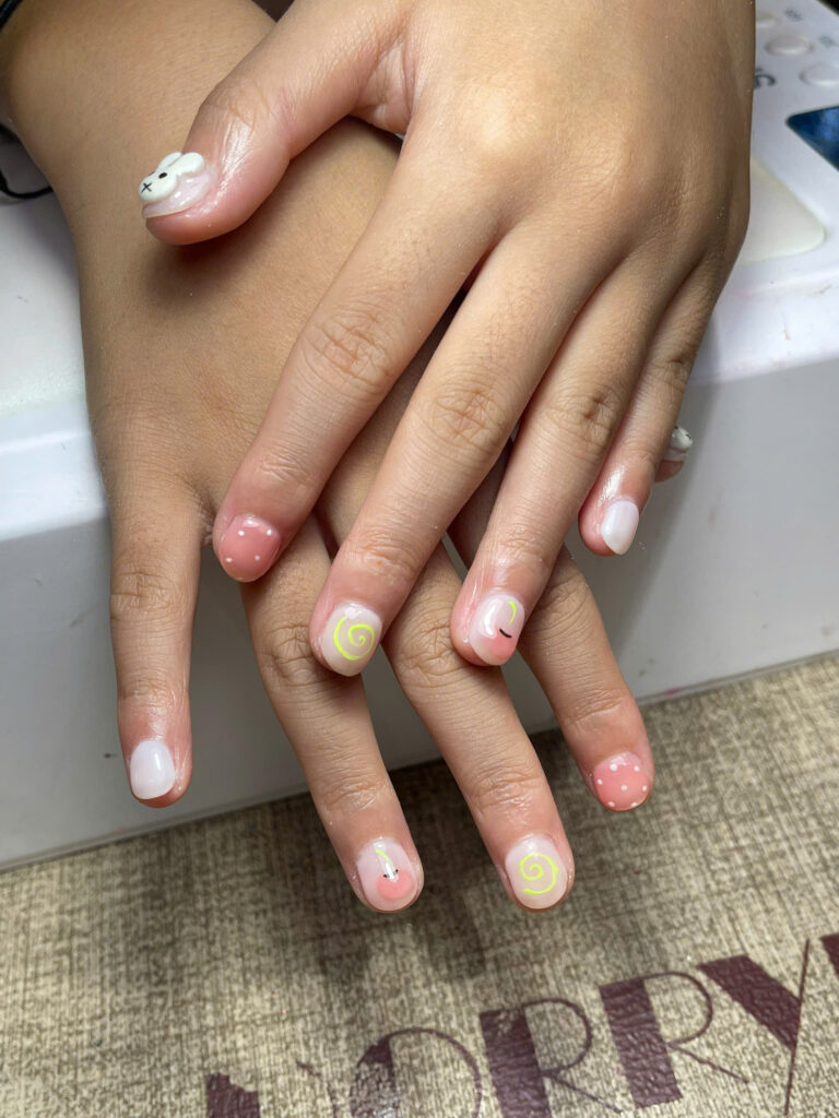 Short natural nails with a 3D bunny charm, neon swirls and dots at Art Spa 2, Hoi An