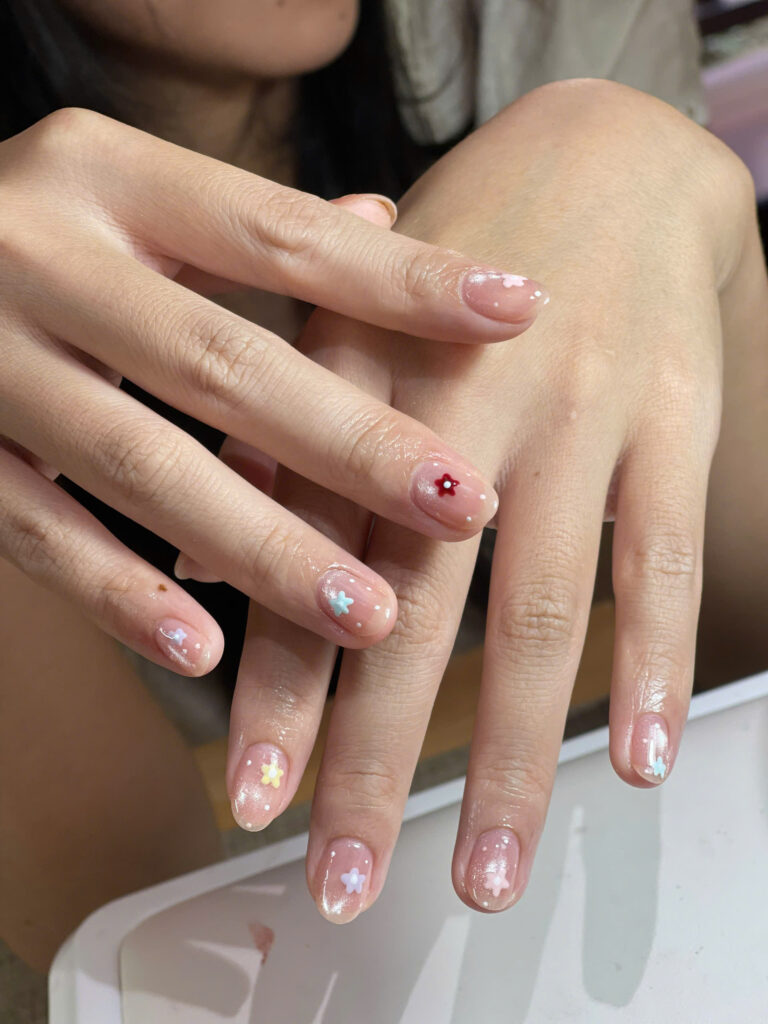 Short oval gel nails with small pastel 3D flowers and white dots at Art Spa 2, Hoi An